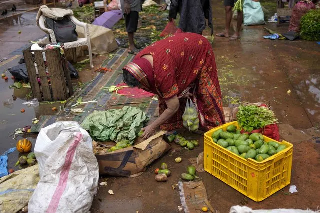 A Sri Lankan woman scavenges for edible mangos at a market place in Colombo, Sri Lanka, Friday, October 21, 2022. (Photo by Eranga Jayawardena/AP Photo)