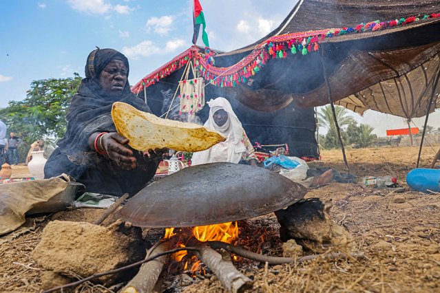 Palestinian women bake flatbread during a ceremony marking the start of the olive harvest season in Deir al-Balah in the central Gaza Strip on October 23, 2022. (Photo by Said Khatib/AFP Photo)