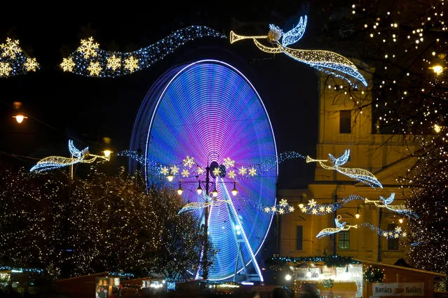 In this long exposure image the Ferris wheel “Debrecen Eye” surrounded by Christmas decorations turns in downtown Debrecen, 221 kms east of Budapest, Hungary, 03 December 2017. (Photo by  Zsolt Czegledi/EPA/EFE)