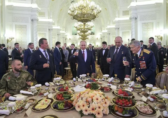 Russian President Vladimir Putin, center, make a toast as he takes part in a reception in honor of the Heroes of the Fatherland in the Kremlin in Moscow, Russia, Thursday, December 14, 2017. (Photo by Alexei Druzhinin, Sputnik/Kremlin Pool Photo via AP Photo)