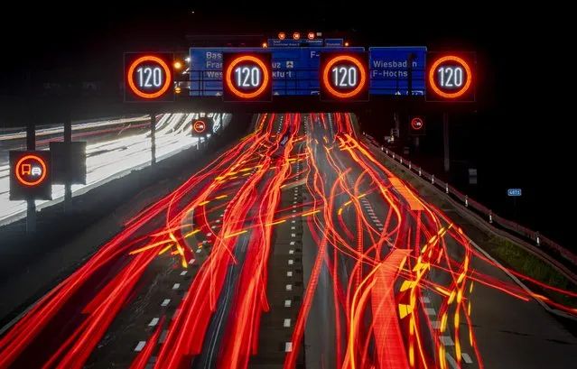 A long exposure photo shows traffic moving along a highway in Frankfurt, Germany, early Thursday, October 6, 2022. (Photo by Michael Probst/AP Photo)