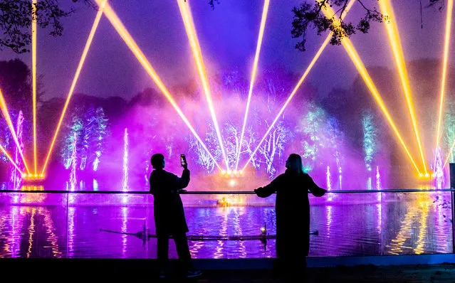 People view an installation over a lake that forms part of the Enchanted Forest Winter Illuminations at Stockeld Park in Wetherby, North Yorkshire on Monday, November 14, 2022. Light effects, a captivating soundscape, and animated installations come together in the ancient woodland once a year over the Christmas period. (Photo by Danny Lawson/PA Images via Getty Images)