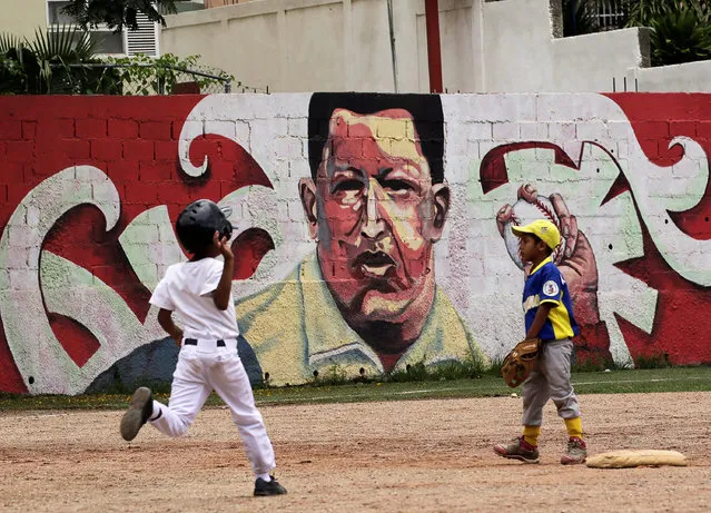 Children play baseball near a mural of Venezuela's late president Hugo Chavez, in Caracas, Venezuela September 8, 2016. (Photo by Henry Romero/Reuters)