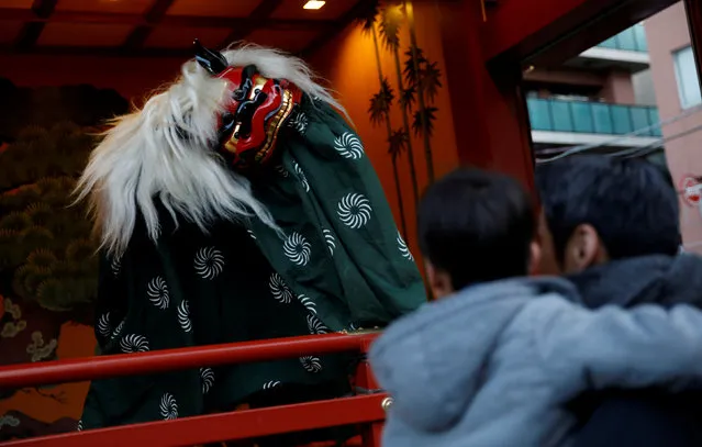 A man and a boy look at a lion dance after they offer prayers on the first day of the new year at a shrine in Tokyo, Japan, January 1, 2018. (Photo by Toru Hanai/Reuters)