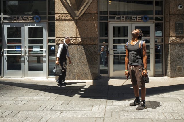 A man squints at the sun during a heat wave on Tuesday, June 24, 2025, in New York. (Photo by Olga Fedorova/AP Photo)