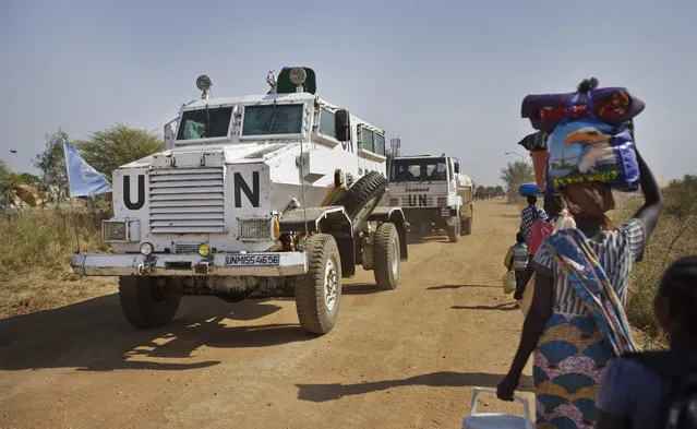 In this Monday, December 30, 2013 file photo, a United Nations armored vehicle passes displaced people walking towards the U.N. Protection of Civilians camp in Malakal, South Sudan. The United Nations peacekeeping mission in South Sudan said on Friday, Sept. 4, 2020 that it has begun withdrawing its troops and police from the protection of civilians camps that continue to shelter more than 180,000 people two years after the end of the country's civil war. (Photo by Ben Curtis/AP Photo/File)