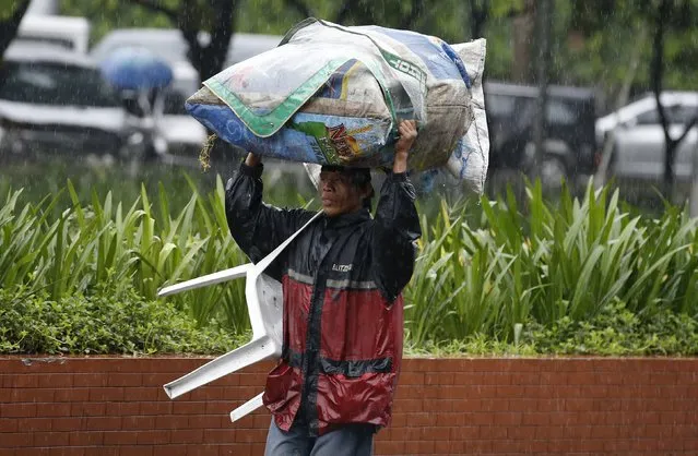 A food vendor carries a sack containing food item as he evacuated due toTyphoon Koppu in Manila, October 18, 2015. (Photo by Erik De Castro/Reuters)