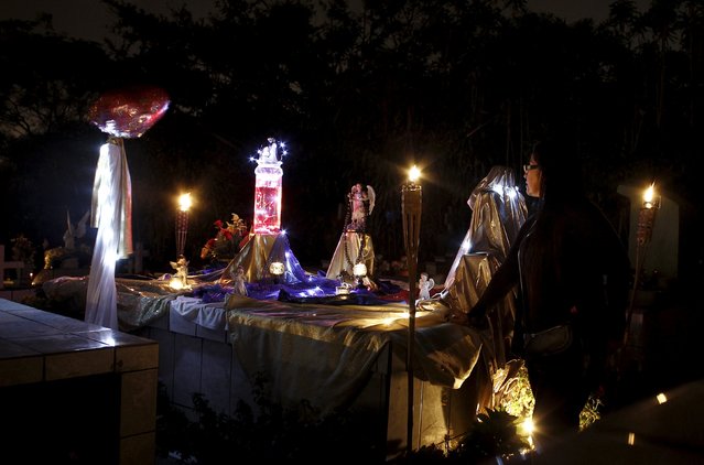 A woman takes part in a vigil at a cemetery in Barva de Heredia, Costa Rica, October 31, 2015. Residents of the area hold vigils in the cemetery to prevent the graves of their loved ones from being vandalised on Halloween, according to local media. (Photo by Juan Carlos Ulate/Reuters)