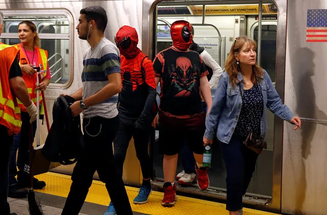 People dressed in costumes walk out of a subway train enroute to the New York Comic Con with other commuters in New York, U.S., October 6, 2016. (Photo by Shannon Stapleton/Reuters)