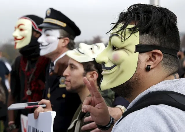Members of the Anonymous Army, with their signature Guy Fawkes masks, have their photo taken with retired Philadelphia police Captain Lewis (2nd L) during their protest in front of the Washington Monument in Washington, November 5, 2015. The group claims to be mobilizing protests in more than 600 cities worldwide as part of what they call the "Million Mask March" held on Guy Fawkes day. (Photo by Gary Cameron/Reuters)
