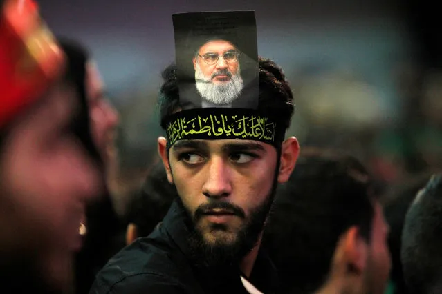 A supporter of Lebanon's Hezbollah leader Sayyed Hassan Nasrallah has his picture on his head during a public appearance by Nashrallah at a religious procession, one day before the Shi'ites will mark the day of Ashura, in Beirut's southern suburbs, Lebanon October 11, 2016. (Photo by Aziz Taher/Reuters)