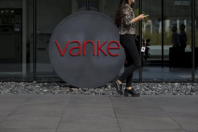 An employee walks past a logo of Vanke at its headquarters in Shenzhen, south China's Guangdong province, November 2, 2015. (Photo by Tyrone Siu/Reuters)