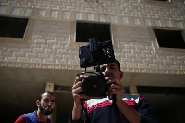 A man looks at the camera during filming a film directed by Humam Husari in the rebel-held besieged town of Zamalka, in the Damascus suburbs, Syria September 19, 2016. (Photo by Bassam Khabieh/Reuters)