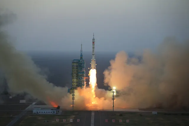 In this photo provided by China's Xinhua News Agency, the Long March-2F carrier rocket carrying China's Shenzhou 11 spacecraft blasts off from the launch pad at the Jiuquan Satellite Launch Center in Jiuquan, northwest China's Gansu Province, Monday, October 17, 2016. China has launched a pair of astronauts into space on a mission to dock with an experimental space station and remain aboard for 30 days. (Photo by Li Gang/Xinhua via AP Photo)