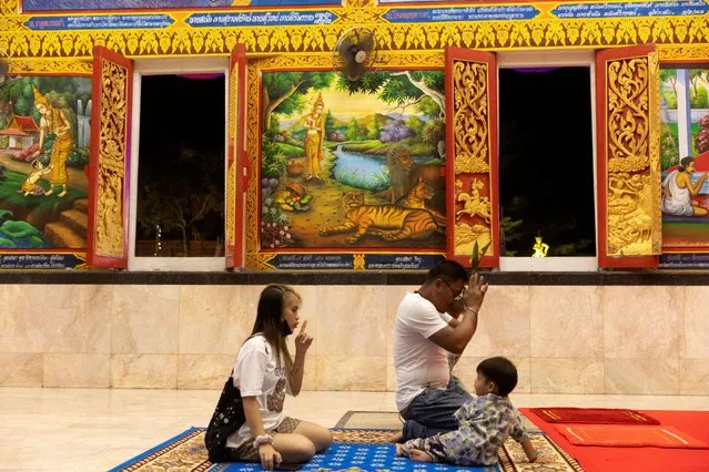 A family prays at Wat Cherngtalay temple during the commemoration of Makha Bucha Day in Phuket, Thailand on March 6, 2023. (Photo by Jorge Silva/Reuters)