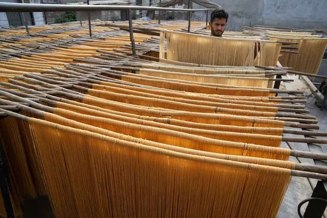 A vendor arranges traditional vermicelli noodles, a favorite during the Muslim's holy fasting month of Ramadan, at a factory, in Lahore, Pakistan, Thursday, March 30, 2023. (Photo by K.M. Chaudary/AP Photo)