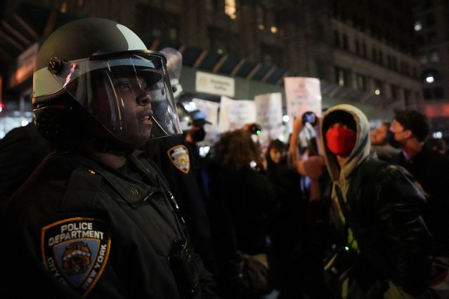 A police officer stands guard as protesters gather outside 26 Federal Plaza, where migrants who were detained during a raid in Lower Manhattan by ICE were brought in, in Manhattan, New York, U.S., October 21, 2025. (Photo by David Dee Delgado/Reuters)