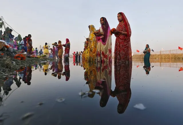Hindu women worship the Sun god Surya in the waters of river Yamuna during the Hindu religious festival of Chatt Puja in New Delhi, India, November 17, 2015. Hindu women fast for the whole day for the betterment of their family and the society during the festival. (Photo by Anindito Mukherjee/Reuters)