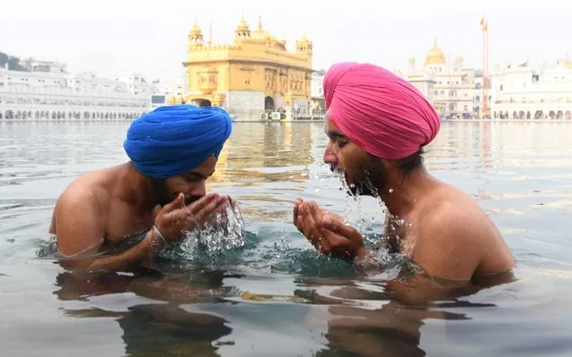 Sikh devotees take a dip in the holy sarovar (water tank) on the occasion of the birth anniversary of the 10th Sikh Guru Gobind Singh at the Golden Temple in Amritsar on January 2, 2020. (Photo by Narinder Nanu/AFP Photo)