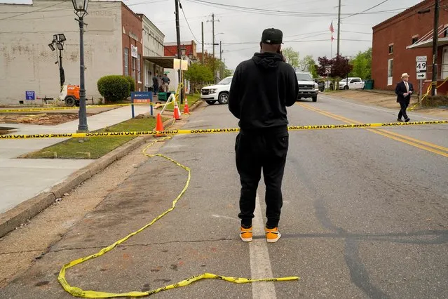 A man speaks on the phone while standing at the edge of the crime scene a day after a shooting at a teenager's birthday party in a dance studio, in Dadeville, Alabama, U.S., April 16, 2023. (Photo by Cheney Orr/Reuters)