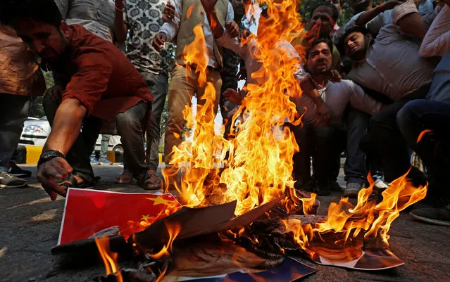 Demonstrators burn Chinese goods and posters of Chinese President Xi Jinping during a protest organised by the activists of Swadeshi Jagran Manch, a wing of the Hindu nationalist organisation Rashtriya Swayamsevak Sangh (RSS), as they demand the boycott of Chinese products, in New Delhi, India, October 26, 2016. (Photo by Adnan Abidi/Reuters)
