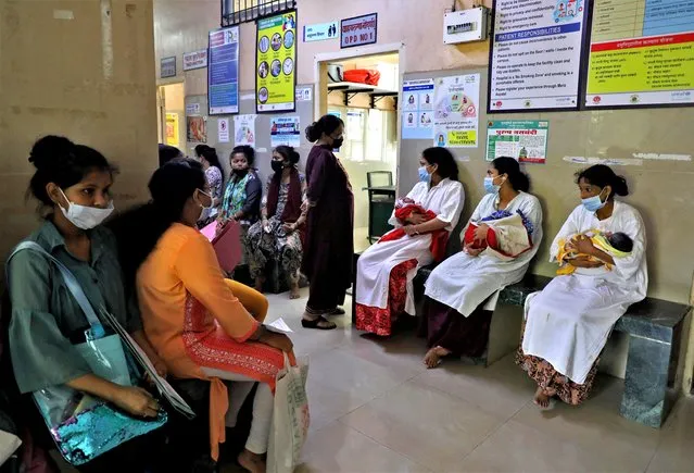 Mothers with their newborn babies wait for a check-up as other women wait for their turn to get antenatal examination outside a doctor's room at a maternity hospital in Mumbai, India on April 25, 2023. (Photo by Niharika Kulkarni/Reuters)
