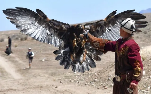 A Kyrgiz hunter spins a lure for a falcon during the Salburun hunting festival in the village of Bokonbayevo, near Lake Issyk-Kul, some 300 km from Bishkek, on April 23, 2023. (Photo by Vyacheslav Oseledko/AFP Photo)