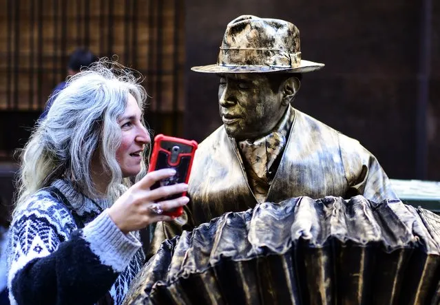 A woman makes a selfie with a performer taking part in the 20th National Contest of Living Statues in Buenos Aires, on September 22, 2019. (Photo by Ronaldo Schemidt/AFP Photo)