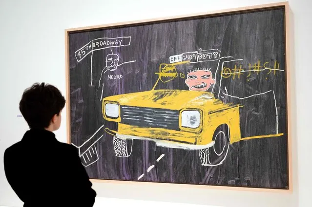 A visitor looks at “Taxi, 45th/Broadway”, an acrylic and oilstick, synthetic polymer and silkscreen ink painting made ca. 1984-1985 by US Neo-expressionism artist Jean-Michel Basquiat (1960-1988) and US artist, film director and producer Andy Warhol (1928-1987), during a preview of the exhibition “Basquiat X Warhol. Painting Four Hands” at the Louis Vuitton Foundation in Paris on March 29, 2023. The exhibition “Basquiat X Warhol. Painting Four Hands” take place from April 5m 2023 to July 28, 2023. (Photo by Bertrand Guay/AFP Photo)
