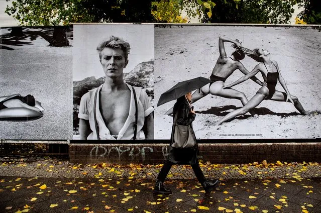 A woman pass by outdoor photo exhibition “Helmut Newton One Hunded” installed at the wall of Kraftwerk Mitte, Berlin, Germany, 30 October 2020. Exhibiton marks the 100th birthday of the master photographer  Helmut Newton. (Photo by Filip Singer/EPA/EFE)