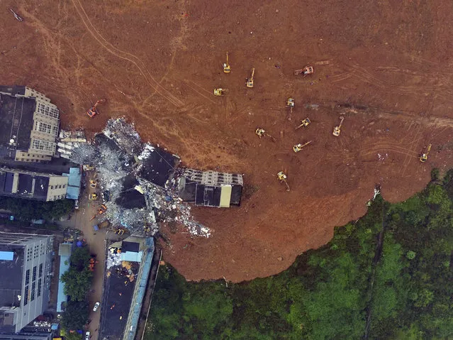 In this photo taken from a drone mounted camera, rescue workers search for survivors in the aftermath of a landslide in Shenzhen in southern China's Guangdong province Monday, December 21, 2015. The massive landslide buried dozens of buildings when it swept through an industrial park in the southern Chinese city of Shenzhen. (Photo by Chinatopix via AP Photo)
