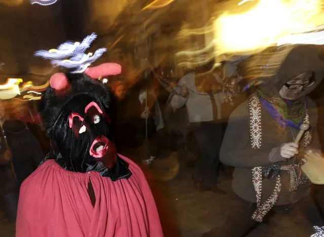 People wear costumes as they participate in the ancient Yule Log dragging tradition during winter solstice celebrations in Riga, Latvia, December 21, 2015. REUTERS/Ints Kalnins