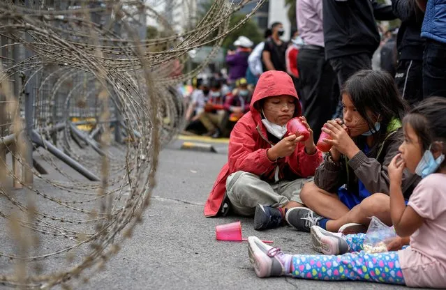Children sit on the floor as members of indigenous communities and supporters of Ecuador's presidential candidate Yaku Perez gather outside the Electoral National Council (CNE) in Quito, Ecuador on February 23, 2021. (Photo by Santiago Arcos/Reuters)