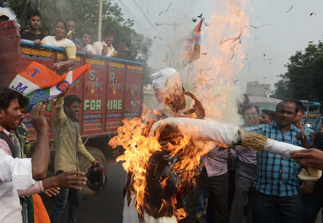 Indian activists from the Trinamool Congress (TMC) political party burn an effigy of Prime Minster Narendra Modi during a rally as part of a nationwide protest against demonetisation in Kolkata on November 28, 2016. Tens of thousands of people turned out November 28 for nationwide protests against India's controversial ban on high-value banknotes, which opposition party organisers say has caused a “financial emergency”. (Photo by Dibyangshu Sarkar/AFP Photo)