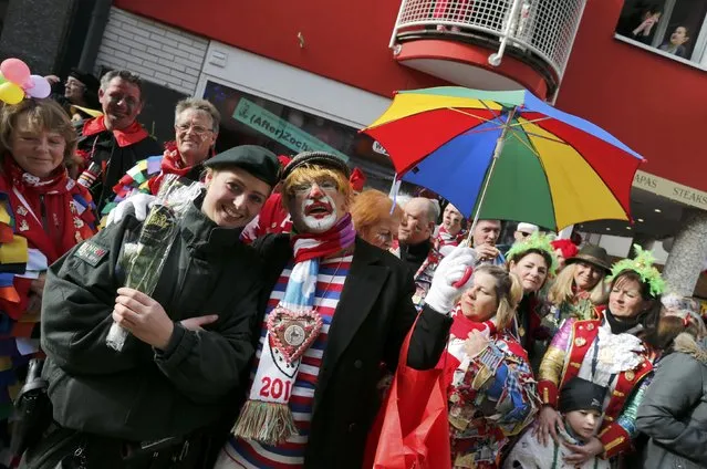Carnival revellers pose with a police officer during the traditional Rose Monday carnival parade in the western German city of Duesseldorf February 16, 2015. (Photo by Wolfgang Rattay/Reuters)