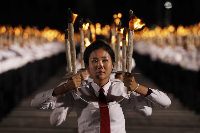 North Korean youths holding torches march during a torch light march at the Kim Il Sung Square in conjunction with the 70th anniversary of North Korea's founding day in Pyongyang, North Korea, Monday, September 10, 2018. Tens of thousands of North Koreans rallied in the square in the final major event of the country's 70th anniversary, an elaborate celebration that was focused on Korean unity and economic development and that deliberately downplayed the missiles and nuclear weapons that brought the North to the brink of conflict with the United States just one year ago. (Photo by Kin Cheung/AP Photo)
