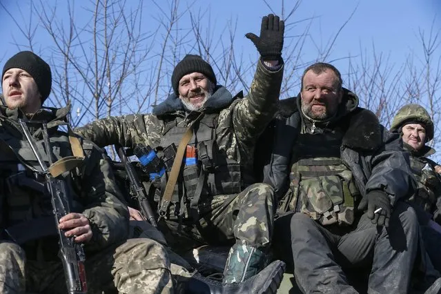 Ukrainian servicemen ride on a military vehicle as they leave area around Debaltseve, eastern Ukraine near Artemivsk, February 18, 2015. (Photo by Gleb Garanich/Reuters)