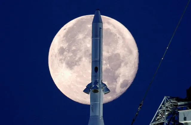 A full moon, known as the “Strawberry Moon” is shown with the top of NASA’s next-generation moon rocket, the Space Launch System (SLS) Artemis 1, at the Kennedy Space Center in Cape Canaveral, Florida, U.S. June 15, 2022. (Photo by Joe Skipper/Reuters)