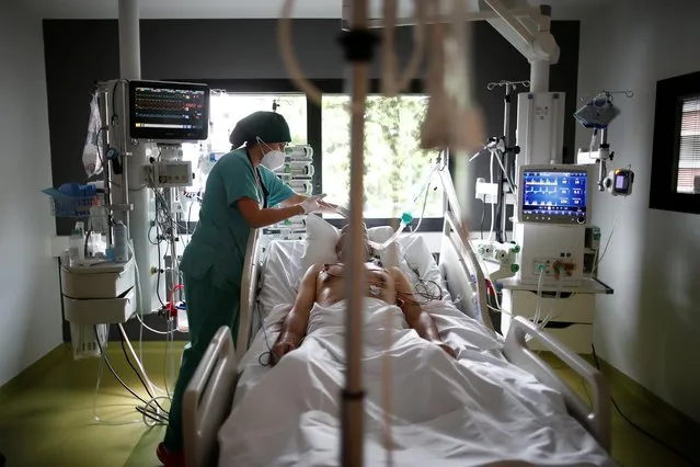 A healthcare worker provides care for a COVID-19 patient in the Intensive Care Unit (ICU) at the Centre Cardiologique du Nord private hospital in Saint-Denis, near Paris, amid the coronavirus disease pandemic in France, May 4, 2021. (Photo by Benoit Tessier/Reuters)