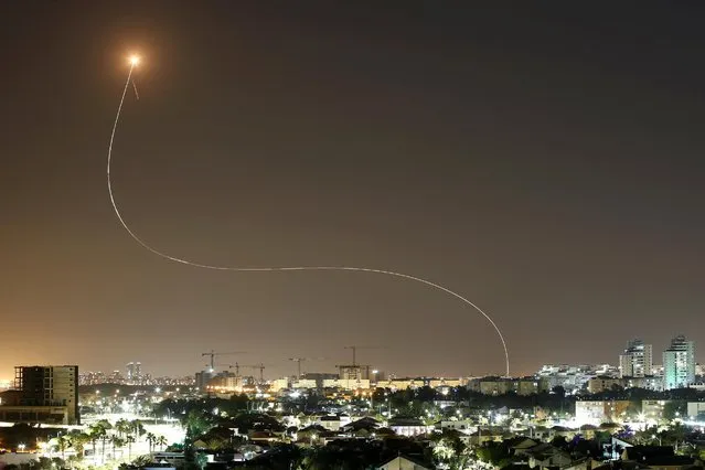 A streak of light is seen as Israel's Iron Dome anti-missile system intercepts rockets launched from the Gaza Strip towards Israel, as seen from Ashkelon, Israel on May 11, 2021. (Photo by Amir Cohen/Reuters)
