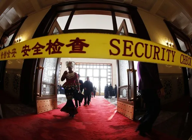 A minority delegate is seen behind security check line as she arrives for  the closing session of the National People's Congress (NPC), China's Parliament, at the Great Hall of the People, in Beijing, March 15, 2015. (Photo by Kim Kyung-Hoon/Reuters)