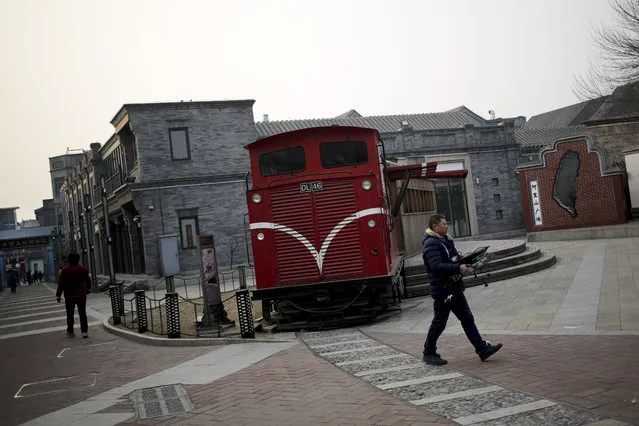 People walk past a mock-train on display at Taiwan's Alishan Square, a commercial area set up by the Taiwanese government near Qianmen Street in Beijing, Thursday, January 21, 2016. For the first time, a huge number of Chinese web users are clamoring to scale the Great Firewall to access websites banned within China. (Photo by Andy Wong/AP Photo)