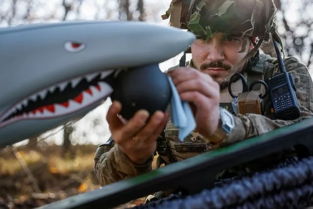 Serviceman of the 15th Separate Artillery Reconnaissance Brigade of the Armed Forces of Ukraine, callsign Buryi, 30-years-old, cleans a camera of a Shark drone before launching, amid Russia's attack on Ukraine, in Kharkiv region, Ukraine on October 30, 2023. (Photo by Alina Smutko/Reuters)