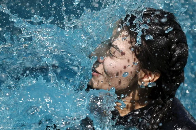 A woman jumps into an icy water tank during the Tough Mudder 10-12 mile obstacle challenge in San Bernardino, California March 28, 2015. (Photo by Lucy Nicholson/Reuters)