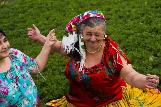 Beatrix Kolompar (L) and Sandorne Kolompar, members of the Terne Lulugya (Young Flowers) Romani Traditional Group dancing in traditional Romani garments in a field in Soltvadkert, 130 kms south of Budapest, Hungary, 07 April 2015. (Photo by Zoltan Balogh/EPA)