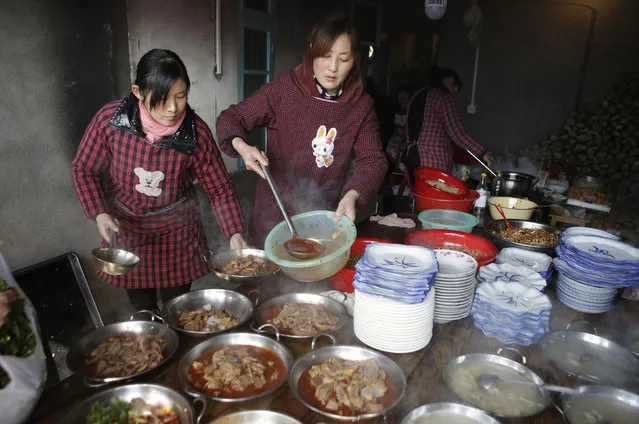 Locals prepare a traditional ethnic Tujia wedding feast for about 2000 guests during celebrations marking the Lunar New Year, in Ziqiu town, Changyang county of China’s Hubei province, February 15, 2016. (Photo by Jason Lee/Reuters)