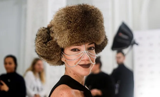 A guest wearing a fur hat looks on before a fashion show by Chinese brand CHNNYU during BRICS+ Fashion Summit in Moscow, Russia on November 29, 2023. (Photo by Maxim Shemetov/Reuters)