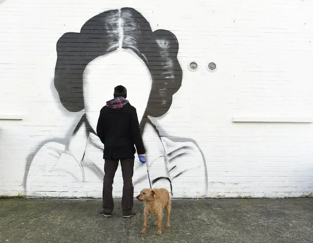 A man and his dog stop to look at a mural depicting Princess Leia from the film Star Wars played by Carrie Fisher in Belfast, Northern Ireland January 11, 2017. (Photo by Clodagh Kilcoyne/Reuters)