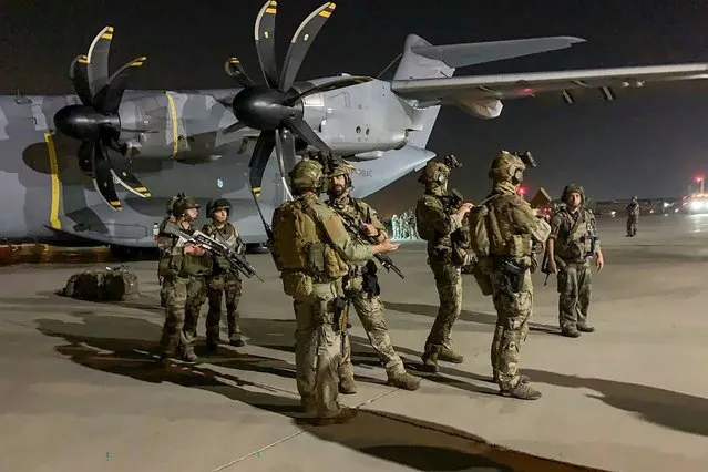 French soldiers stand guard near a military plane at airport in Kabul on August 17, 2021, as they arrive to evacuate French and Afghan nationals after the Taliban's stunning military takeover of Afghanistan. (Photo by AFP Photo/Stringer)