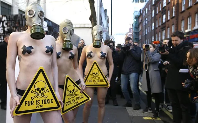 Models wearing gas masks stand outside the main venue of London Fashion Week, in Soho, London,  Friday, February 19, 2016. The PETA supporters were reminding attendees that fur clothing and accessories are cruel to animals  and toxic to humans. “There's nothing fashionable about fur torn from the bodies of struggling animals and then laden with chemicals that are dangerous to people who wear it”, says PETA Associate Director Elisa Allen. (Photo by Kirsty Wigglesworth/AP Photo)